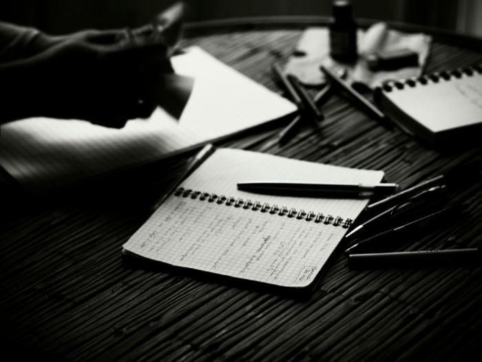 Photo noir et blanc de carnets et de stylos.